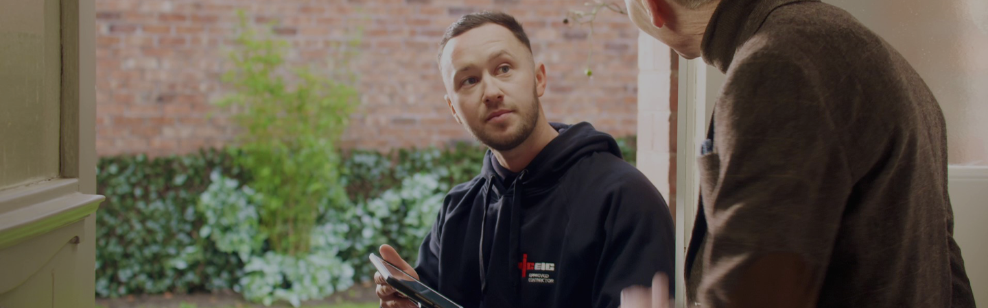 An approved NICEIC contractor, visiting a householder to discuss work undertaken.