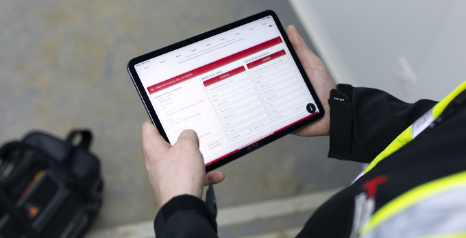 An approved NICEIC contractor, holding a digital tablet looking through the NICEIC award-winning pocket guide app.