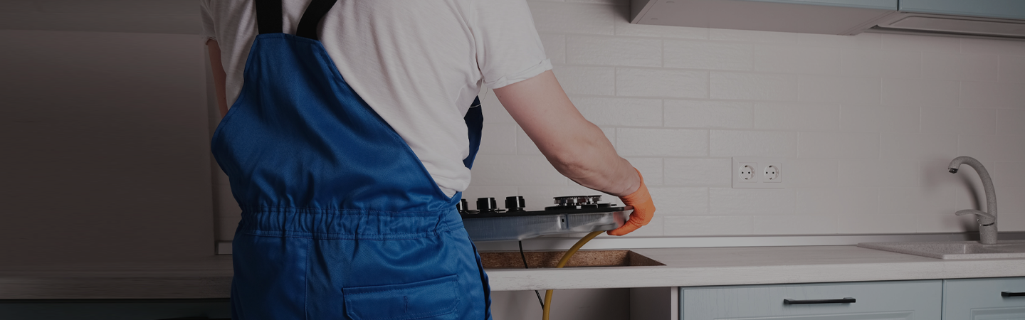 Installing a new gas hob in a modern kitchen chip board counter top.