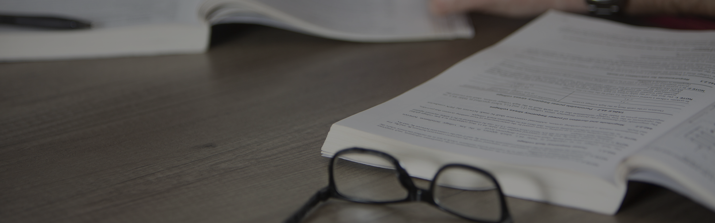 A person studying a legislation booklet on a office table.